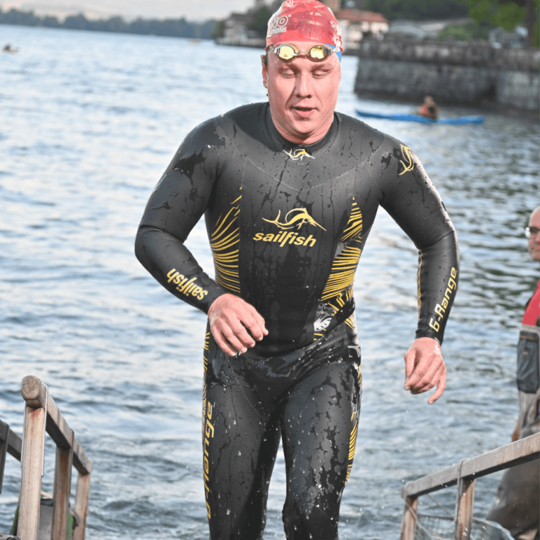 Markus Marthaler mit Neoprenanzug aus einem See steigend.